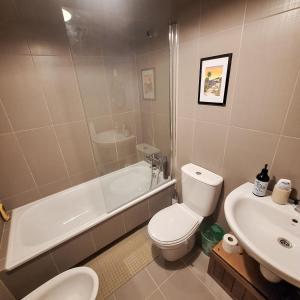 a bathroom with a toilet and a tub and a sink at Aliving Colo in Raxó +40 photos