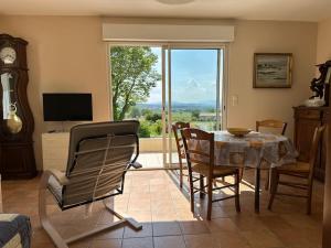 a living room with a table and chairs and a window at Maison au calme avec jardin in Brouzet-lès-Alès