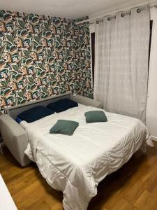 Una cama con dos almohadas encima en un dormitorio. en My House, en Choisy-le-Roi
