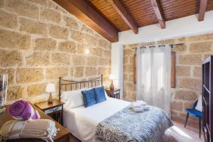 Un dormitorio con una cama y una pared de piedra. en Apartamento Jávea Pueblo, en Jávea