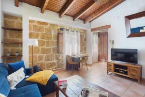 Una sala de estar con un sofá azul y un televisor. en Apartamento Jávea Pueblo, en Jávea