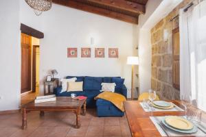 Una sala de estar con un sofá azul y una mesa. en Apartamento Jávea Pueblo, en Jávea