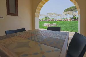a table with chairs and a view of a yard at Masseria Casina Vitale in Ceglie Messapica