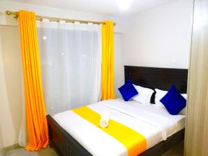 a bedroom with a bed with blue and orange curtains at Rew Apartment in Nairobi