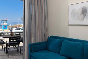 a living room with a blue couch and a patio at Chara Sea View Luxury House in Limenas