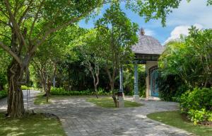 a walkway in a park with trees and a gazebo at Jumeirah Bali in Uluwatu