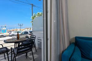 a living room with a table and chairs and a balcony at Chara Sea View Luxury House in Limenas