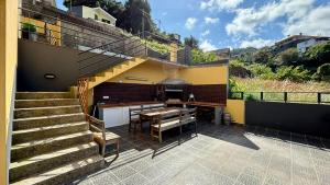 uma casa com um pátio com uma mesa e escadas em Ocean Hill House em Santa Cruz - Madeira