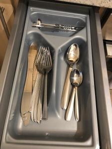 a tray with silver utensils in a sink at Spacious City Centre flat free parking& superfast WIFI in Edinburgh