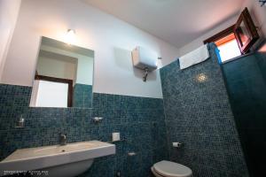 a bathroom with a sink and a toilet and a mirror at B&B Baglio Maragani in Maragani +38 photos