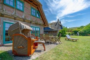 a house with a yard with chairs and a grill at Fachwerkhäuser Gager - Haus 2 in Gager