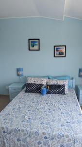 a bedroom with a bed with a blue and white bedspread at Guest House Chalakov in Sinemorets