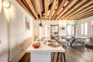 a kitchen and living room with a wooden ceiling at Ospizio delle Donzelle in Venice +35 photos