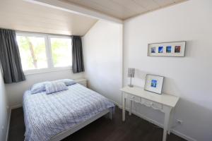 a bedroom with a bed and a desk and a window at Le bonheur les pieds dans l'eau in Thonon-les-Bains +30 photos