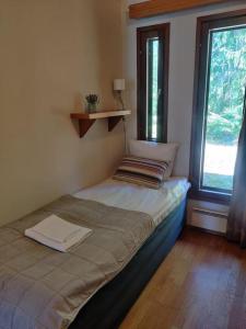 a small bed in a room with two windows at Kylpyla Spa, Saimaa Villa Efrat B8 in Imatra