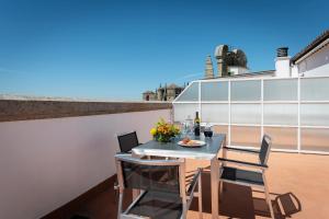 a balcony with a table and chairs on a roof at Dorma Alfonso VIII in Plasencia +38 photos