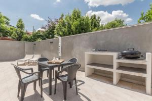 a patio with a table and chairs and a grill at Villino in centro con cortile interno, wifi e aria condizionata in Codigoro