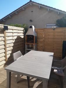 einen Tisch und Stühle auf einer Terrasse mit Grill in der Unterkunft Maisonette by the sea in Frontignan