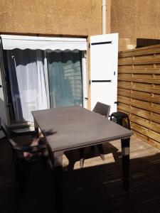 einen Holztisch und Stühle in einem Zimmer mit Terrasse in der Unterkunft Maisonette by the sea in Frontignan