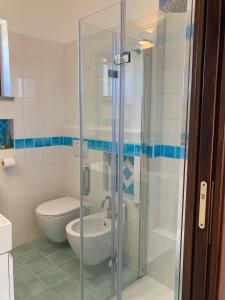 a bathroom with a glass shower with a toilet at Appartamento Vista Mare - Amazing Sea View Apartment in Stintino +14 photos
