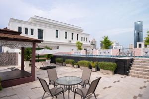 a patio with a table and chairs and a building at Syama Hana Executive Apartments Thonglor in Bangkok