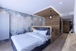 a bedroom with a large white bed and a blue wall at Alm- & Wellnesshotel Alpenhof in Schönau am Königssee