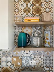a shelf with a teapot on it in a kitchen with tiles at Foscolo 20 in La Spezia