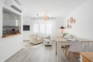eine Küche und ein Wohnzimmer mit einem Tisch und einem Schreibtisch in der Unterkunft Apartamento Jávea Puerto in Jávea