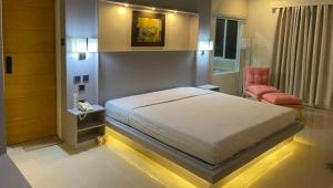 Un dormitorio con una cama grande y una silla. en Pagadian Bay Plaza Hotel, en Pagadían