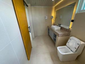 a bathroom with a toilet and a sink at Pagadian Bay Plaza Hotel in Pagadian +12 photos