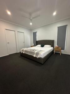 Holiday Home at Golf Course Townsville في تاونزفيل: غرفة نوم بسرير كبير في غرفة