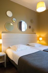 a bedroom with a bed and mirrors on the wall at Résidence de Tourisme Vacances Bleues Villa Regina in Arcachon
