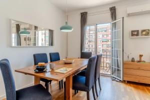 a dining room with a wooden table and chairs at Canela Homes BARCELONA FIRA in Barcelona