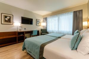 a hotel room with a bed and a desk at TURIM Europa Hotel in Lisbon +76 photos