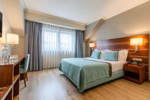 um quarto de hotel com uma cama e uma secretária em TURIM Europa Hotel em Lisboa