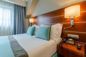 a hotel room with a bed and a telephone at TURIM Europa Hotel in Lisbon