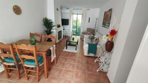 a dining room and living room with a table and chairs at La casa de mayfer in Benamahoma
