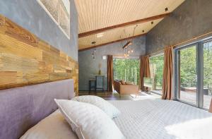 een slaapkamer met een groot bed en een groot raam bij Ramiau - su gamta 