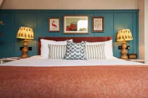 a bedroom with a bed with blue walls and two lamps at Mill on the Exe in Exeter