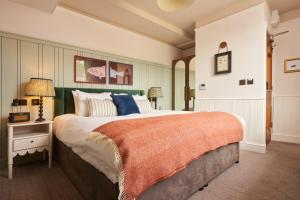 a large bedroom with a large bed and a table at Mill on the Exe in Exeter