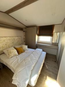 a bedroom with a large bed with white sheets and pillows at mobil home climatisé in Grimaud +7 photos