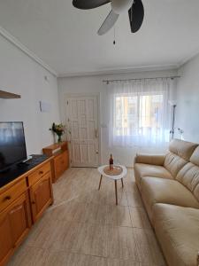 a living room with a couch and a flat screen tv at Casa Rosalia in Orihuela Costa