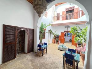 un pasillo con un arco con mesas y sillas azules en Dar Mounia, en Rabat