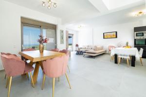 a living room with pink chairs and a table at Etheria Villa in Chania Town