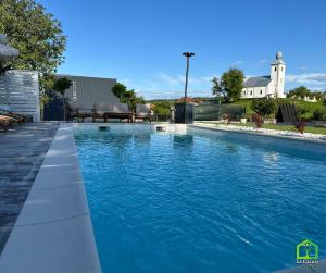a swimming pool with blue water in a yard at La Căsuțe in Silvaşu de Jos