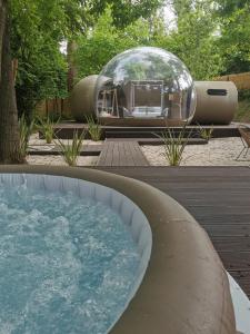 a glass dome in a yard with a tub of water at Glamping I Mulini in Crecchio