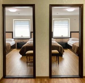 a mirror in a room with two beds at Hotel Koral in Chernivtsi