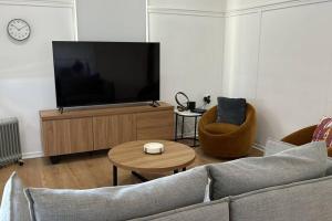 a living room with a tv and a couch and a table at Vandy Beach Cottage in Clontarf