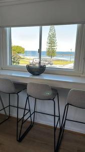 a table with two chairs in front of a window at Vandy Beach Cottage in Clontarf