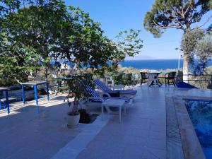 d'une terrasse avec des chaises et des tables et une vue sur l'océan. dans l'établissement ASIA APART HOTEL, à Kusadası